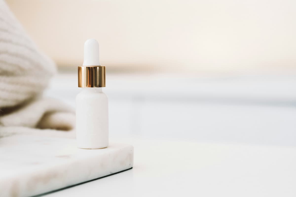 Skincare serum dropper bottle on neutral background